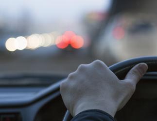 Hand on a steering wheel.
