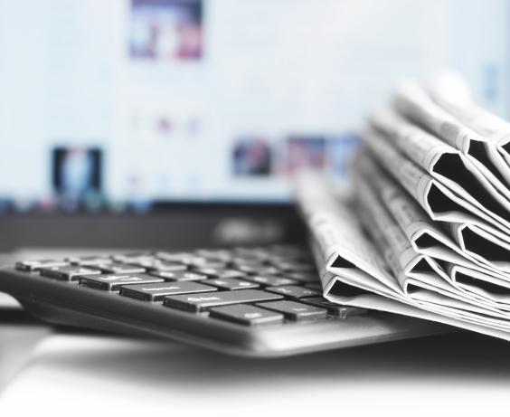 Pile of newspapers on a computer keyboard.